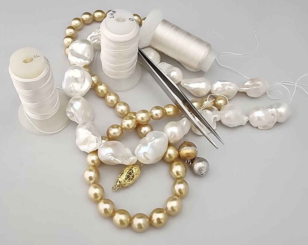 Pearl strands, beading thread spools, and tweezers arranged for pearl restringing.